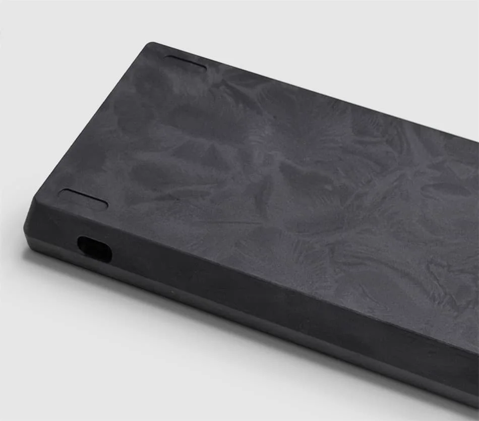 Carcasa negra con textura de plumas y abertura USB visible