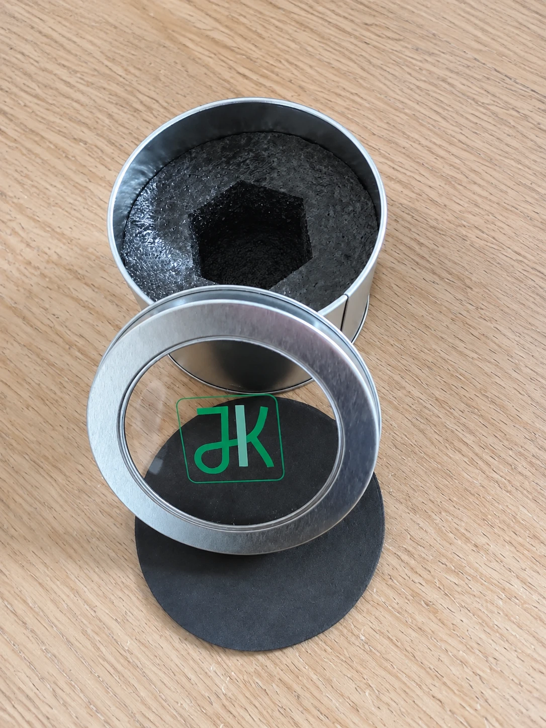 Round presentation tin with a custom brand mark and protective insert
